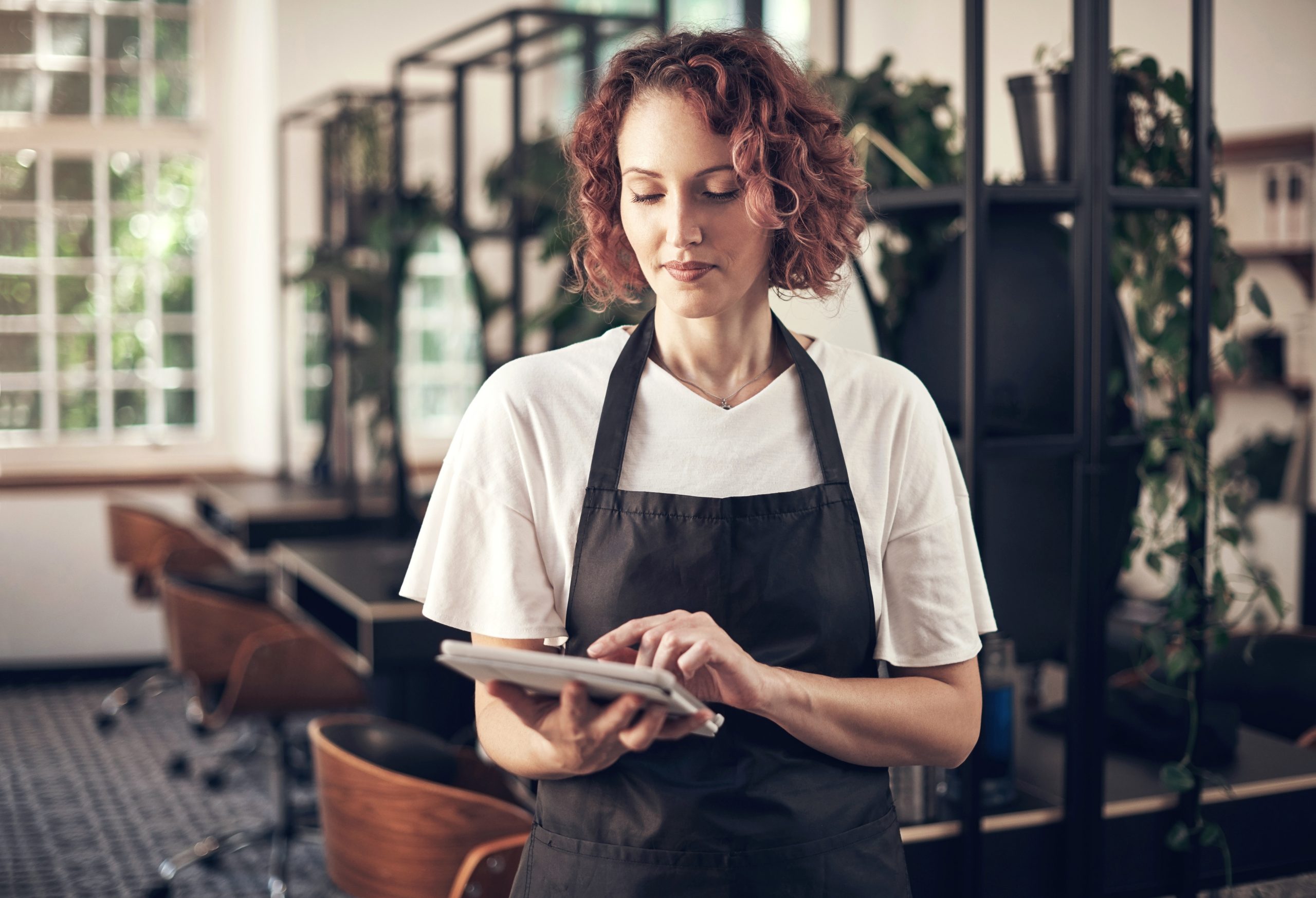 A salon owner taking a payment on a tablet
